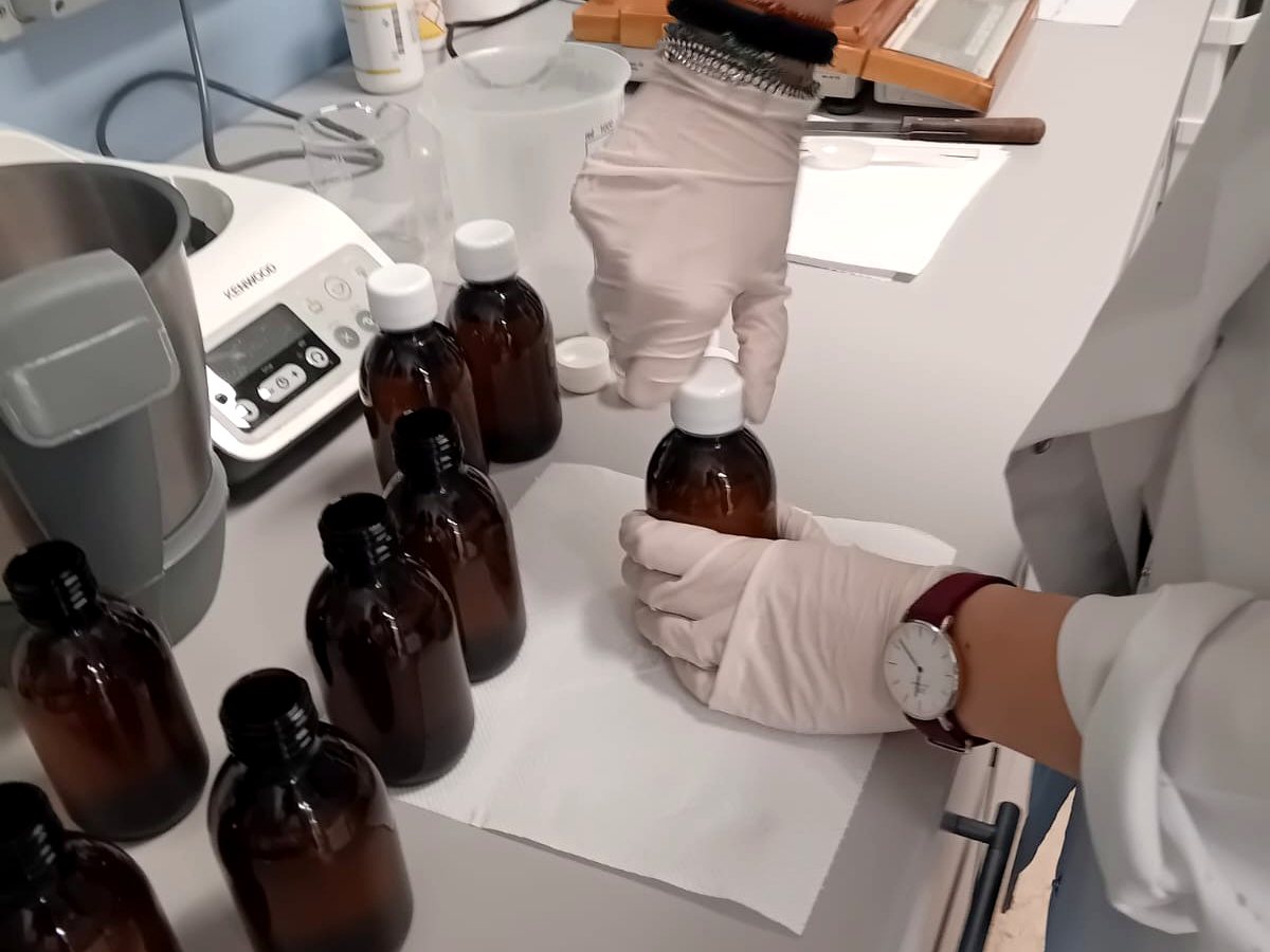 Fase di confezionamento in flaconi nel laboratorio galenico di Amafarmacia Mortari