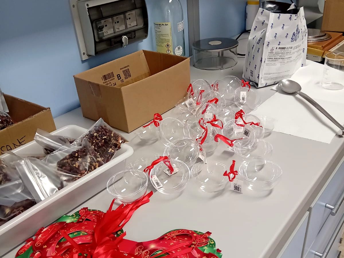 Preparazione delle confezioni natalizie nel laboratorio di Amafarmacia Mortari