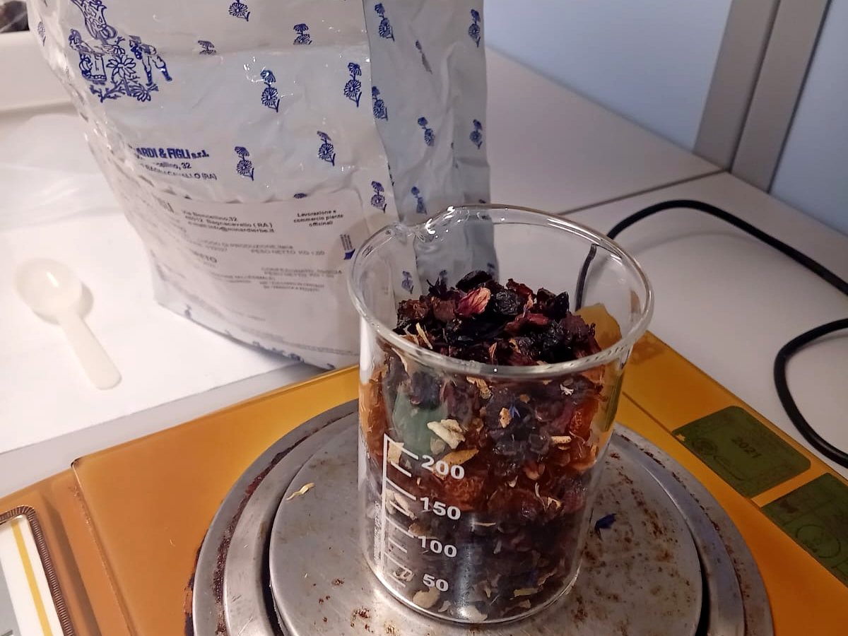 Pesata di una miscela per tisana nel laboratorio di Amafarmacia Mortari