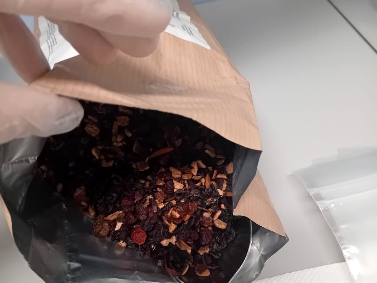 Riempimento di una busta con una miscela per tisana nel laboratorio di Amafarmacia Mortari